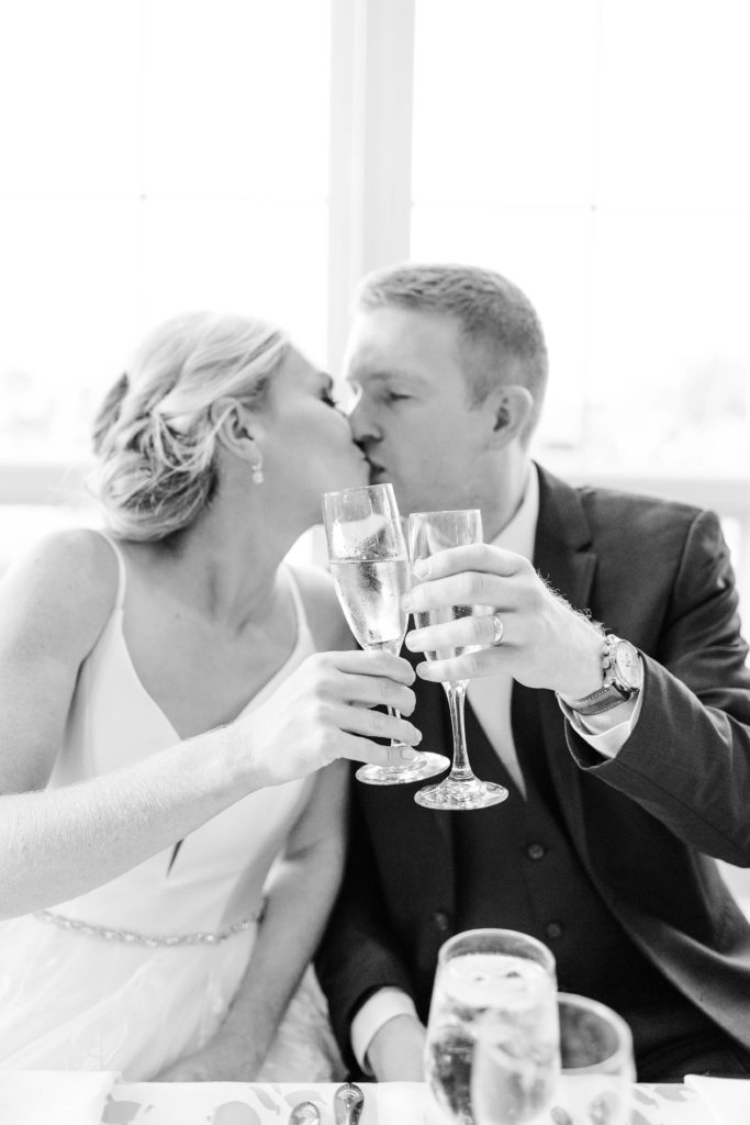 bride and groom clink glasses